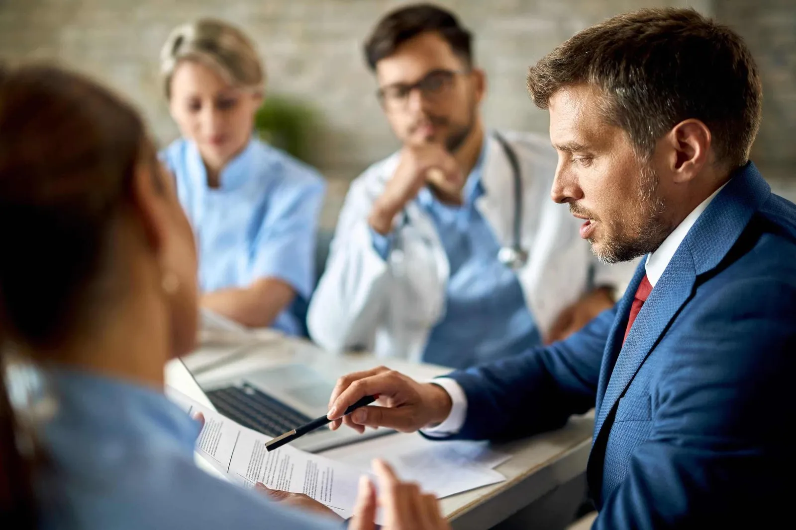 lawyer discussing medical malpractice types with patient and doctors