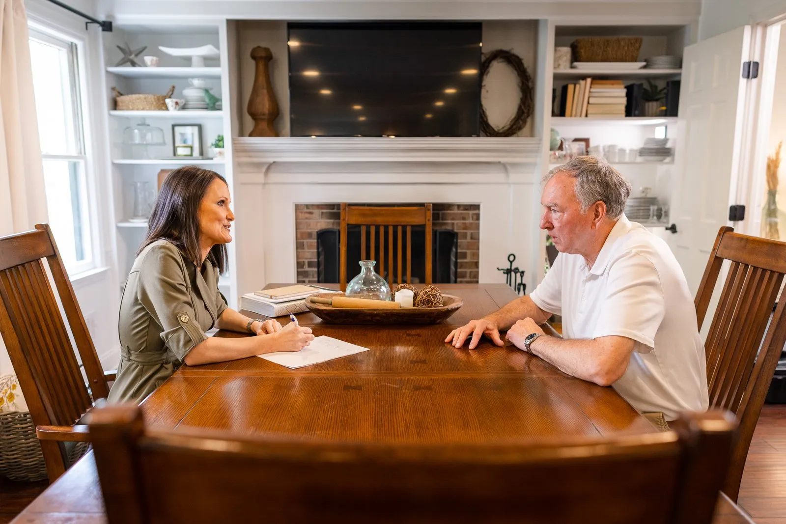 Female attorney at John B. Jackson Law Firm meeting with man in his home discussing the statute of limitations and how quickly they need to proceed.