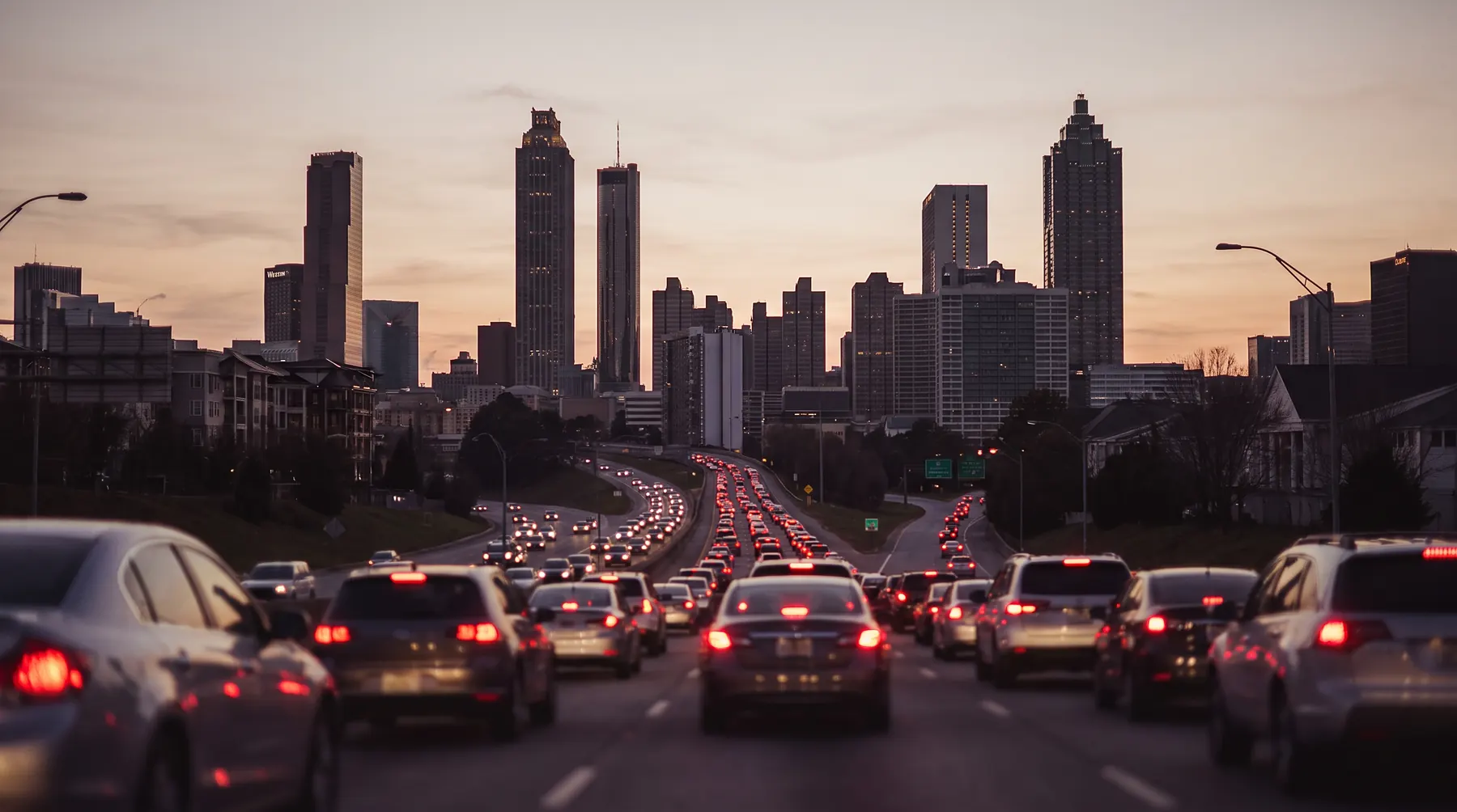 Downtown Atlanta skyline at dusk seen past stopped bumper-to-bumper highway traffic