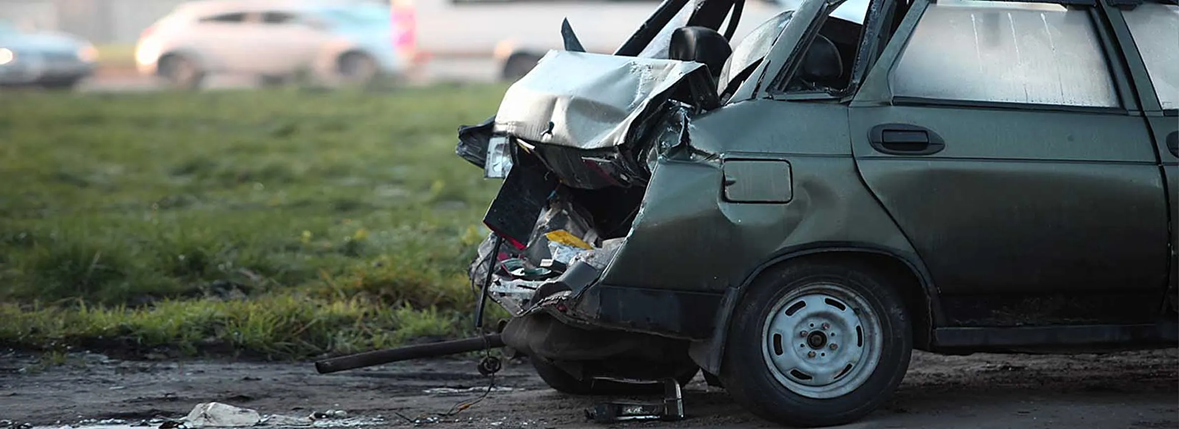 Badly damaged car on the roadside after a serious accident