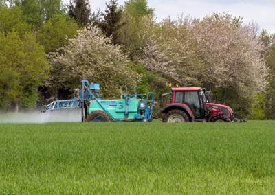 This image shows a farmer spraying his crops with Roundup