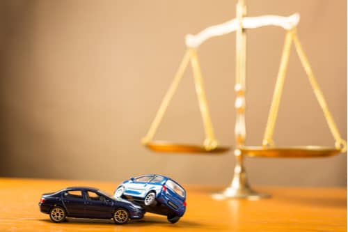Rome car accident lawyer concept crashed toy cars and scales of justice