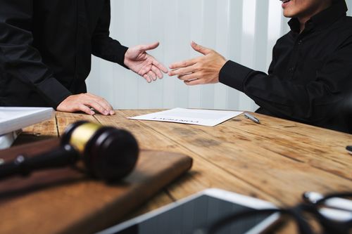 Image is of a Carrollton car accident lawyer meeting with a client and they are shaking hands