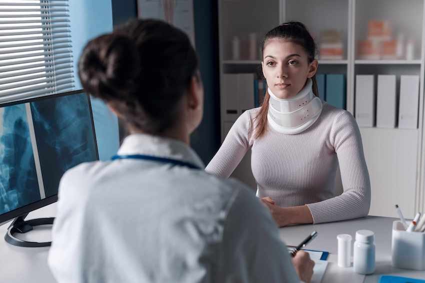 injured woman speaking with woman doctor per her personal injury law firm