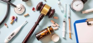 gavel and medical equipment and pills laid out representing medical malpractice types